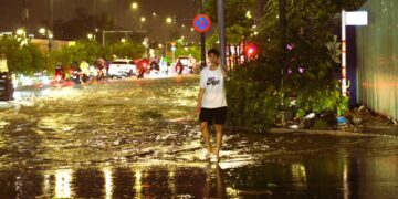 Sài Gòn mưa đêm, thanh niên dừng xe dẫn người đi đường tránh ngập