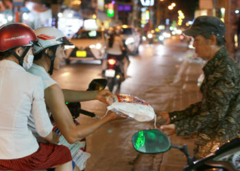 Hai vợ chồng lặng thầm chở gạo tặng người nghèo bên đường đêm Sài Gòn