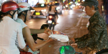 Hai vợ chồng lặng thầm chở gạo tặng người nghèo bên đường đêm Sài Gòn